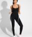 Vrouw in zwarte sauna jumpsuit met ritssluiting en weerstandsband, vooraanzicht.