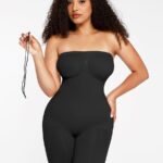 Vrouw in zwarte strapless butt-lifting bodysuit met bandje in hand, vooraanzicht.