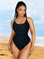 Vrouw in zwart badpak met buikplooiing op het strand.