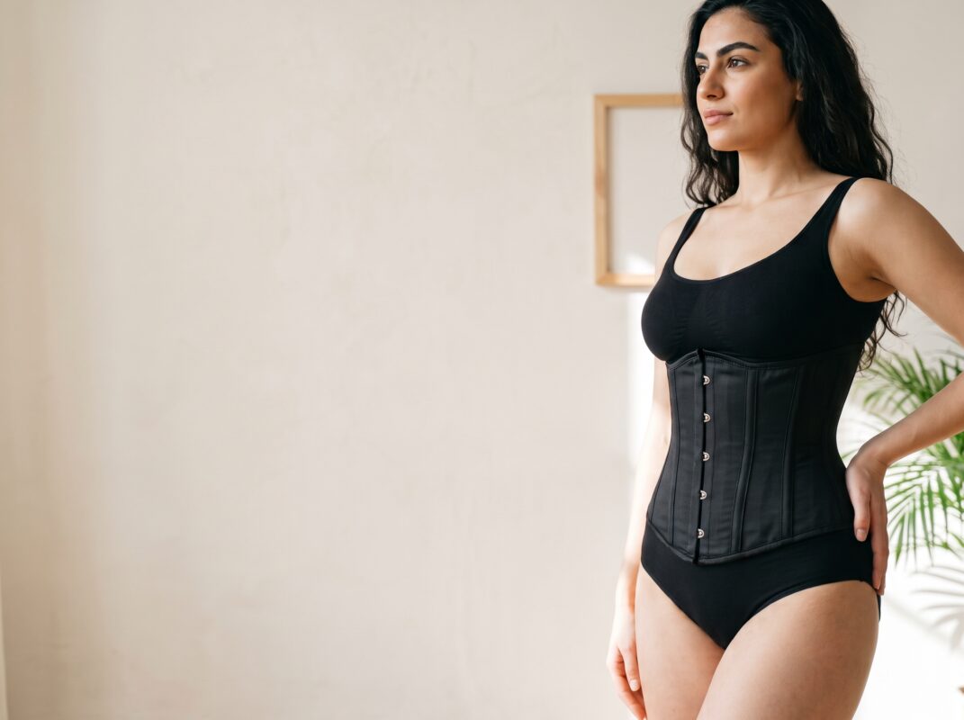 Vrouw met zwarte taille trainer corset met baleinen, hoofd banner.