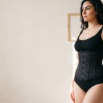 Vrouw met zwarte taille trainer corset met baleinen, hoofd banner.